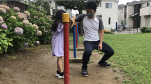 鉄棒におへそをくっつけたまま逆上がりをする女の子