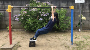 台に乗って鉄棒の豚の丸焼きをする女の子
