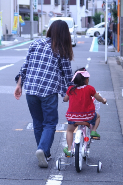 自転車に乗っている女の子と横にいるお母さん