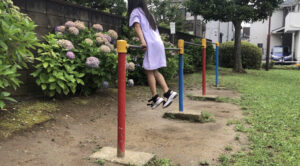 鉄棒のつばめをして後ろにジャンプする女の子
