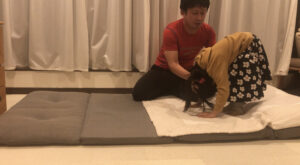 前転をする女の子を補助する男の人