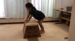 開脚跳びの準備のポーズをしている女の子