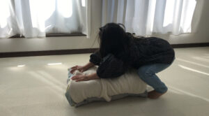 枕で跳び箱をしている女の子