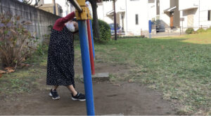 鉄棒のこうもりで体を振る女の子
