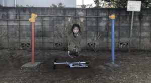 鉄棒のブランコで着地をする女の子