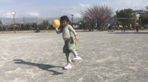 片手でボールをオーバースローで投げる女の子