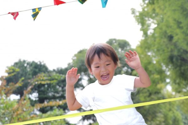 運動会でゴールをする男の子