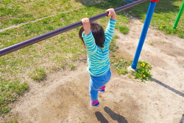 鉄棒にぶら下がっている男の子