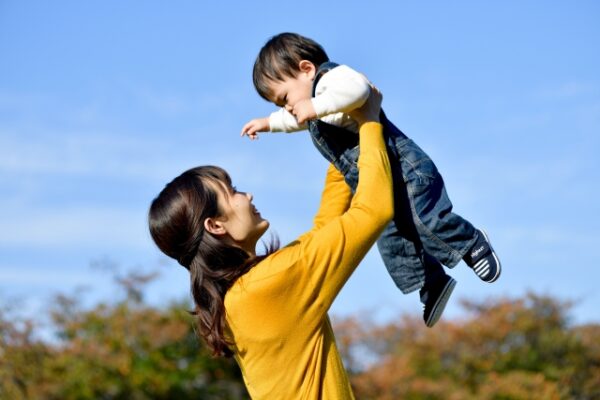 子どもを抱きあげてるお母さん