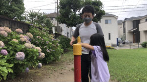 鉄棒のお布団でお尻と肩を持って補助するお父さん