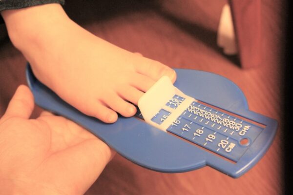 靴のサイズを測っている子ども