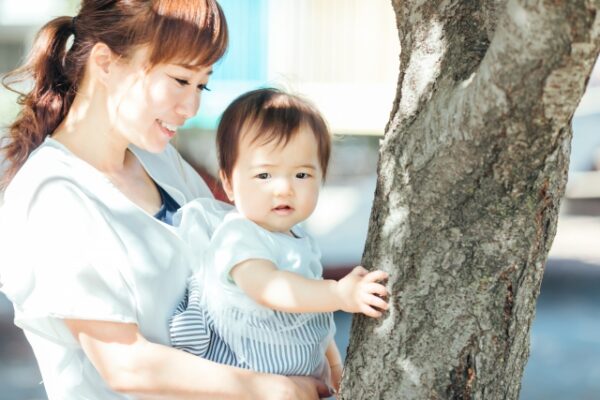 赤ちゃんを前に向かせて抱っこするお母さん