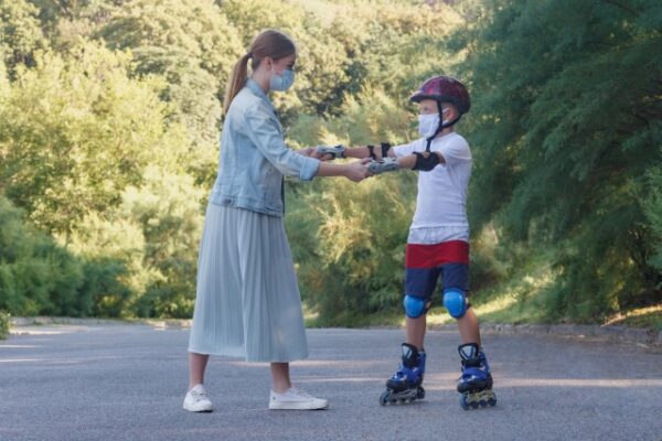 お母さんが両手を持ってインラインスケートをする男の子