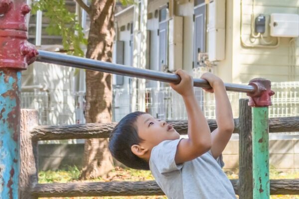 逆上がりをしようとしている男の子