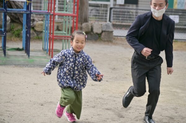 かけっこをしている女の子とお父さん