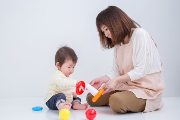 お母さんとおもちゃで遊んでいる赤ちゃん