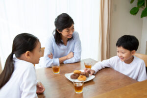 おやつを食べている子ども達と見ているお母さん