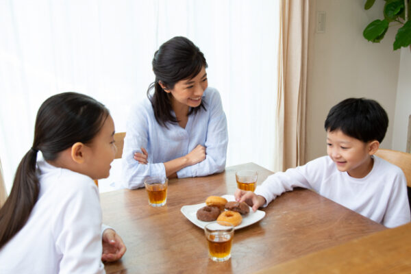 おやつを食べている子ども達と見ているお母さん