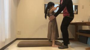立っている状態からブリッジをしている女の子と前から補助しているお父さん