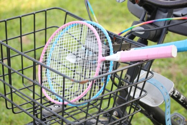 バトミントンのラケットがのった自転車のかご