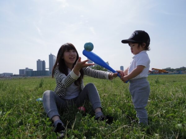 お母さんとバットとボールで遊んでいる男の子